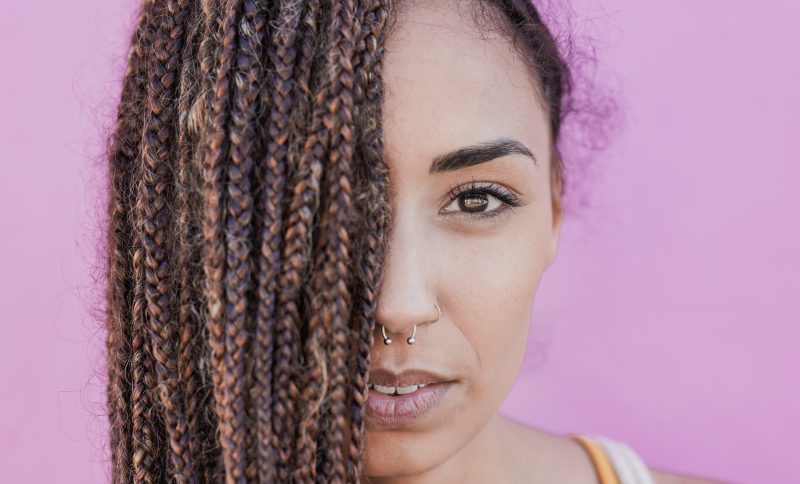 Beautiful mixed race woman with braids looking on camera